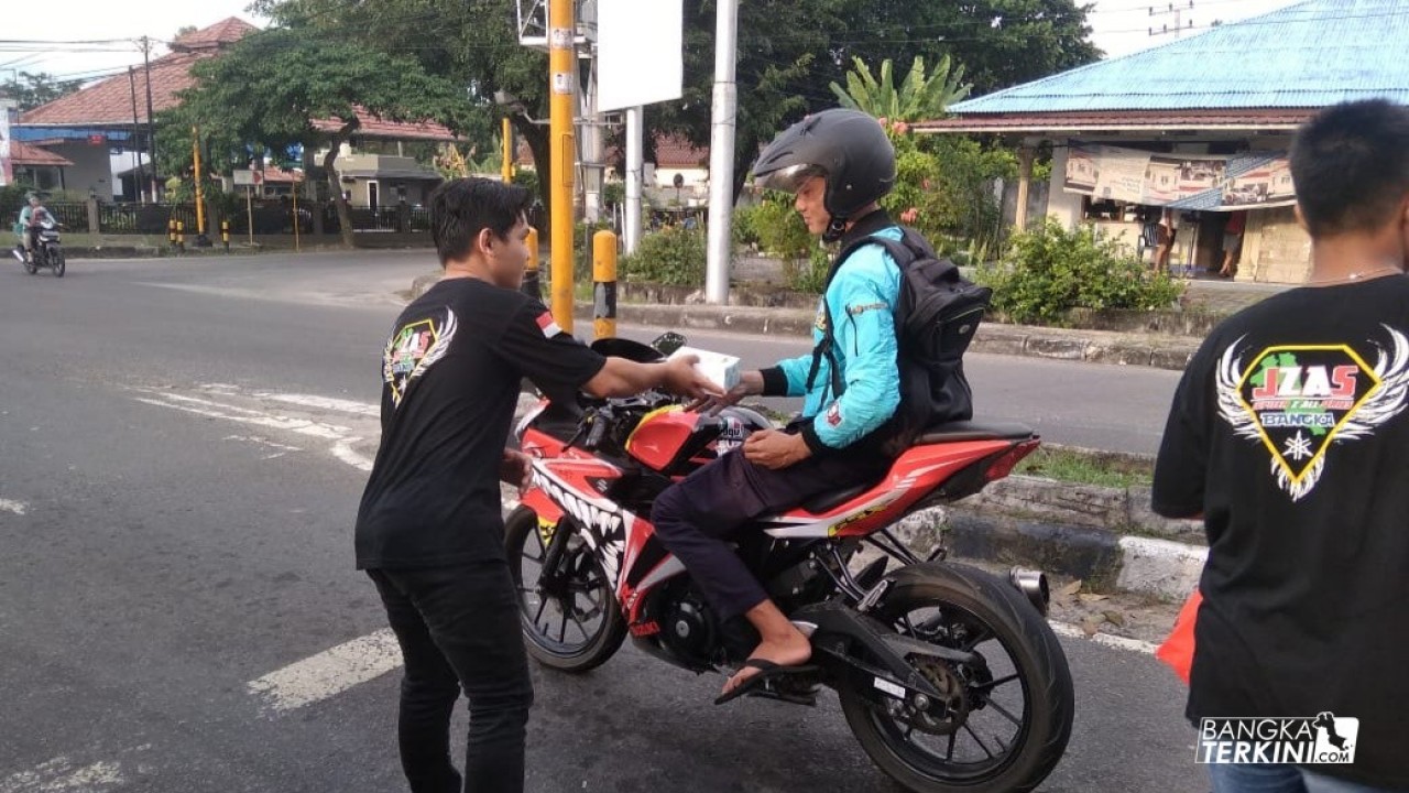 komunitas motor MAGIC, MSB, JZAS bagikan takjil kepada pengendara motor yang melintas di lampu merah dan keluarga pasien di RSUD Sungailiat, Minggu (19/05/2019).