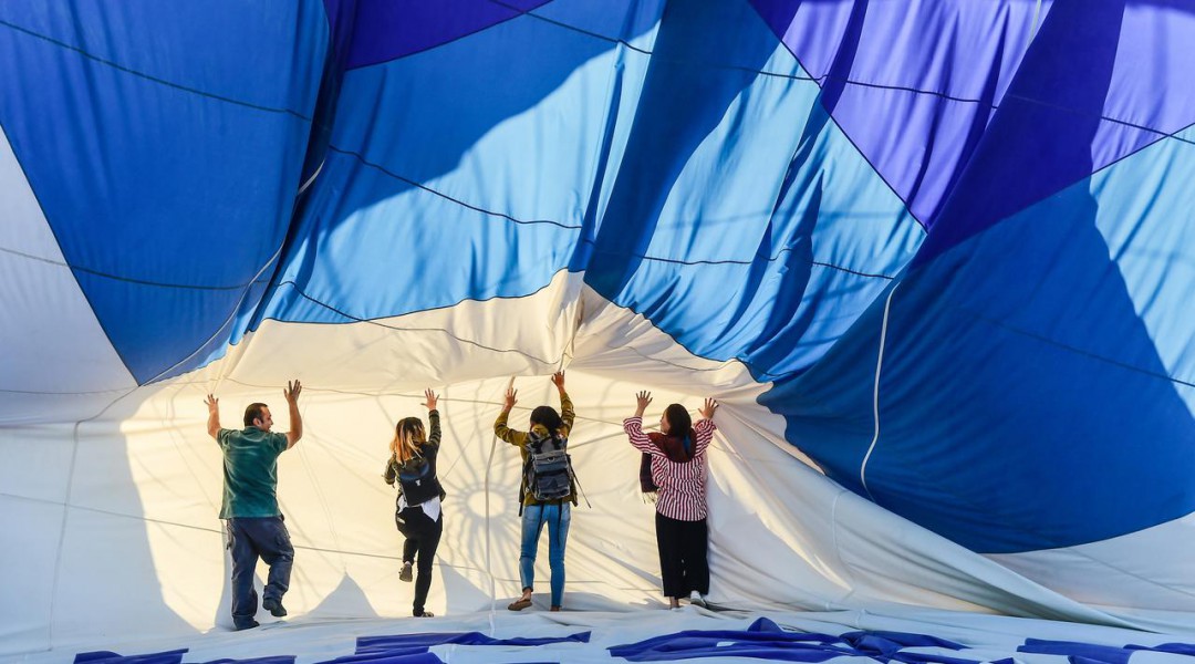 Wisatawan bersiap melakukan penerbangan dengan balon udara panas di atas Nevsehir di wilayah Cappadocia, Turki (5/9). Balon udara panas yang terbang di atas Cappadocia juga menjadi pemandangan menarik bagi para wisatawan. (AFP Photo/Yasin Akgul)