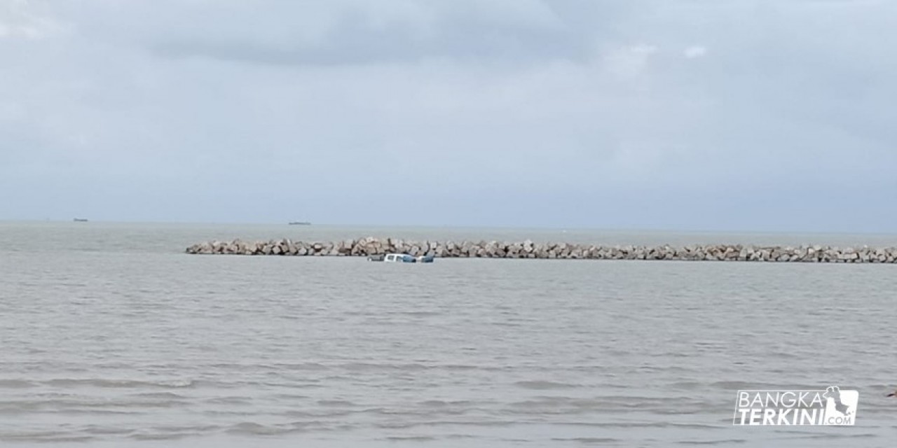 Mobil milik Dinas Koperasi UMKM Pemkot Pangkalpinang, terjebak lumpur dan terendam oleh pasangnya air laut di Pantai Pasir Padi, Sabtu (30/06/2018).